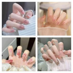 Blush pink press-on nails showing gradient color, plaid accents, faux pearls, and heart decorations