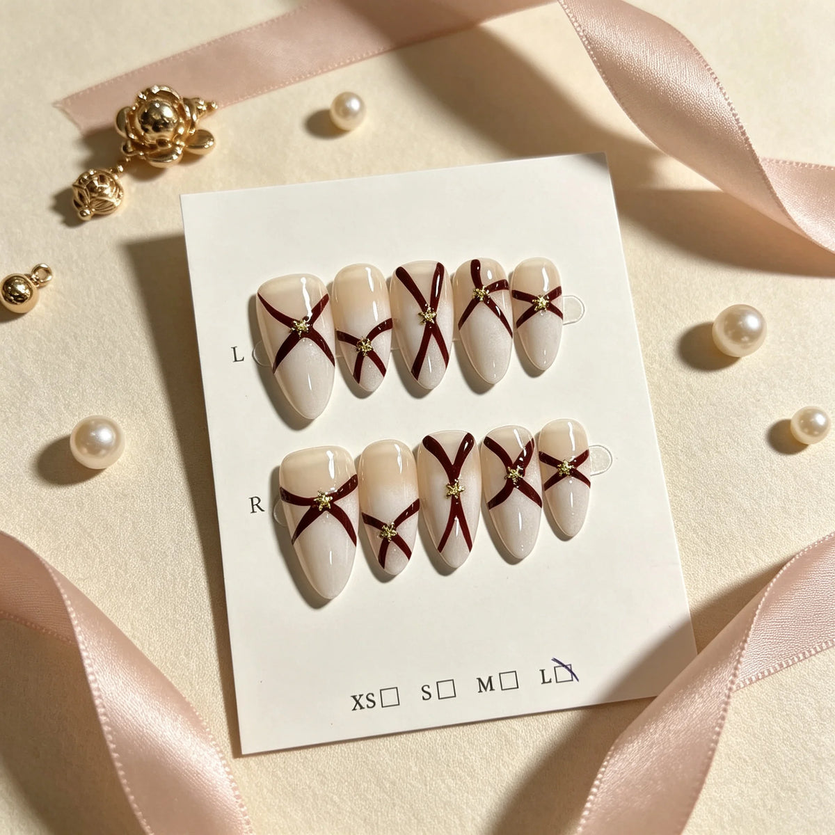 Pink, green and gold full-cover false nails showing ribbon bow design details